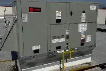 Professional commercial HVAC technician servicing rooftop unit